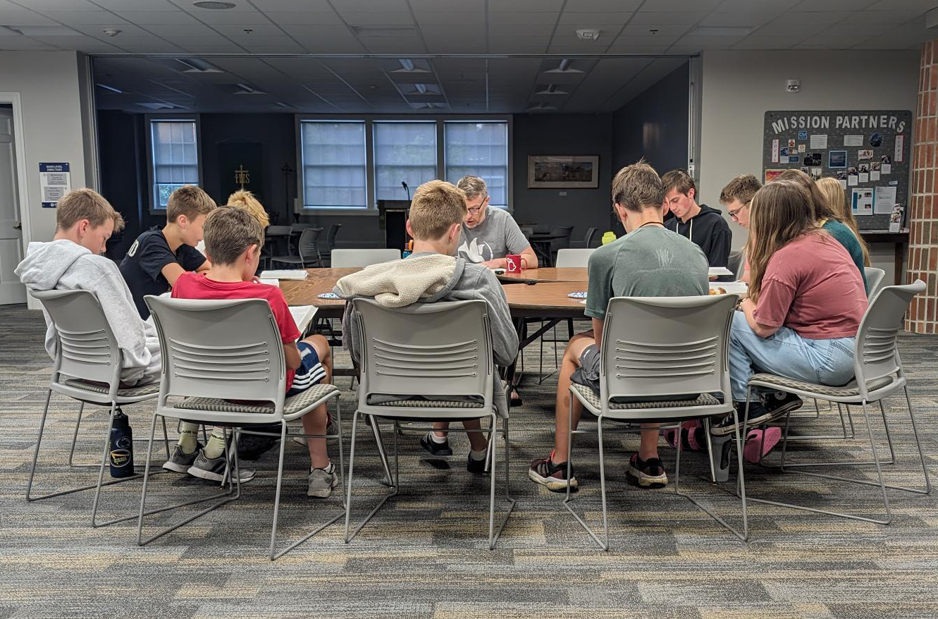 Image of a teen group sitting in chairs around a table